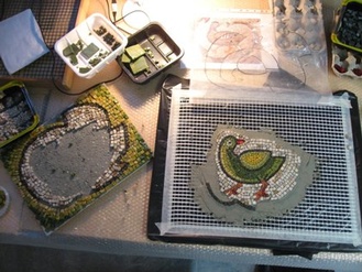 mosaiikkilintu siirtyy pieni alue kerrallaan luonnostelupohjalta tuoreelle laastille. Mosaiikki ja kuvat Marja Louni.